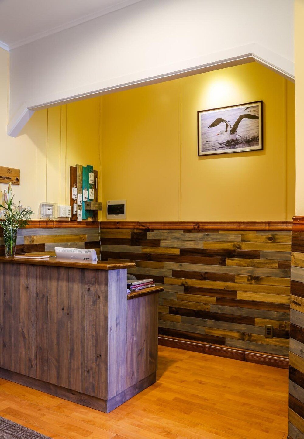 Reception area with a wooden desk and a yellow wall