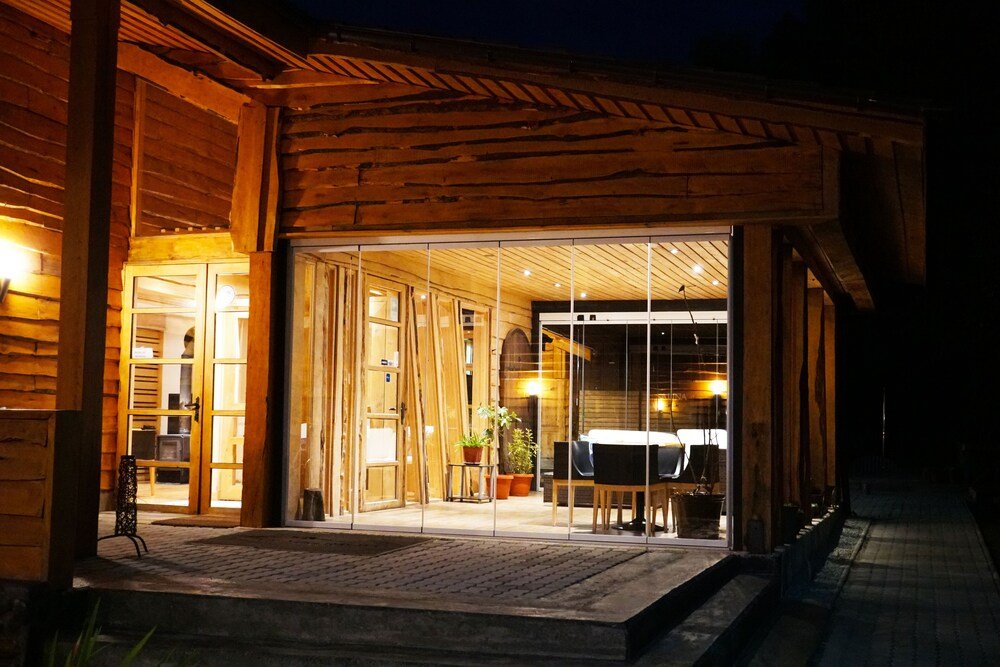Wooden building with a glass entrance, brick pathway and potted plants