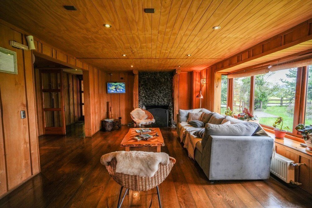 Acogedor salón de madera con chimenea y asientos cómodos