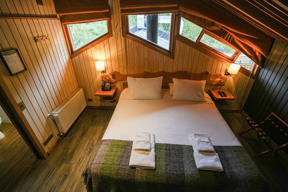Dormitorio acogedor revestido en madera con cama grande