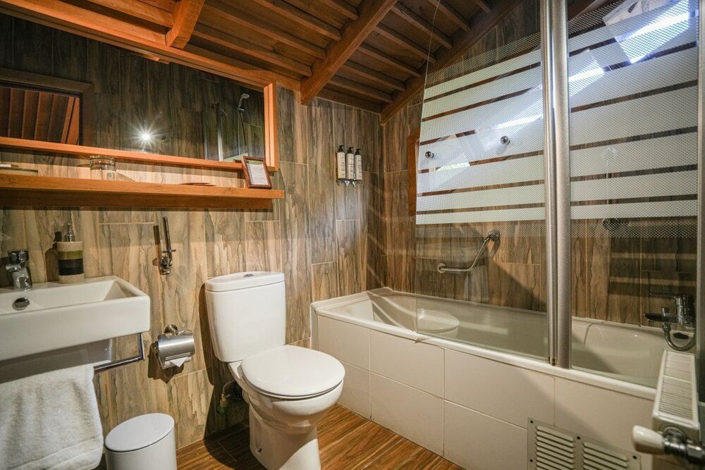 Baño con techo de madera y una bañera