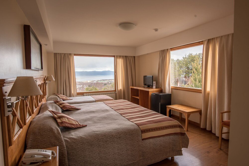 Hotel room with two beds, a desk and a television