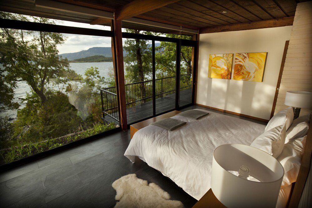 Bedroom with a large window overlooking the lake at Antumalal