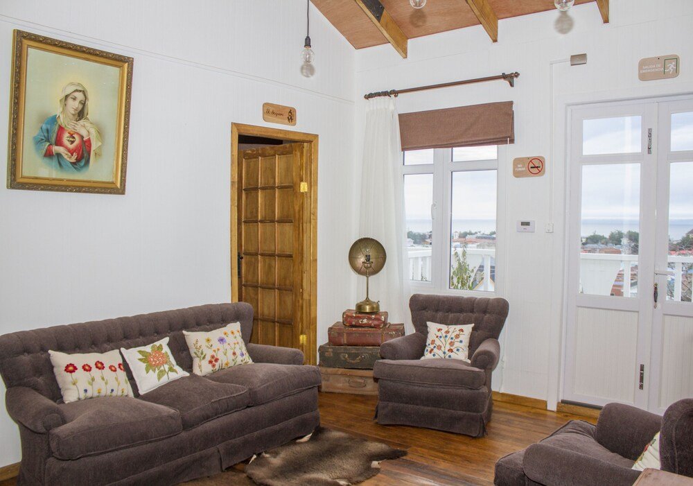 Sala con juego de sofás marrones y una puerta de madera