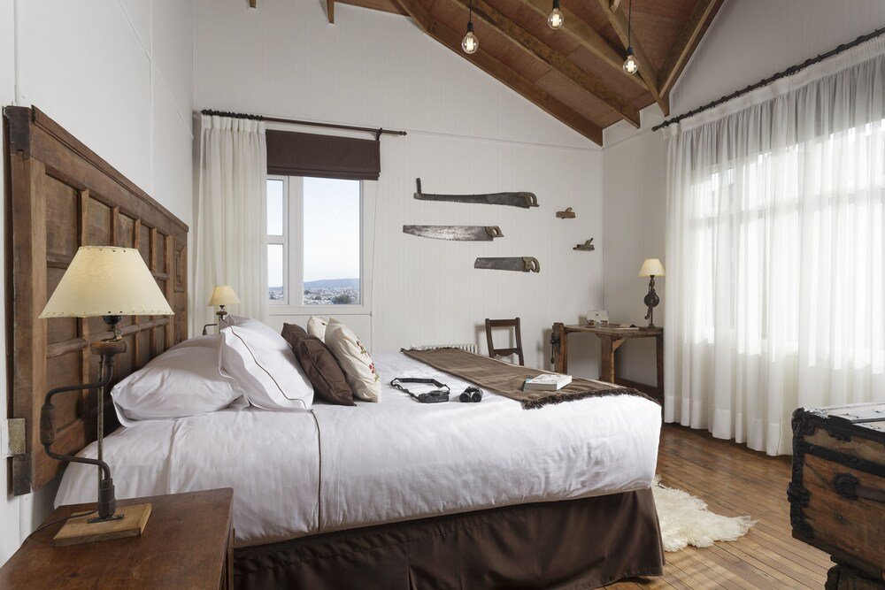 Dormitorio con cabecera de madera y ropa de cama blanca