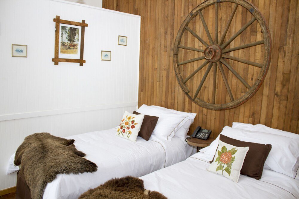 Habitación con dos camas y pared de madera