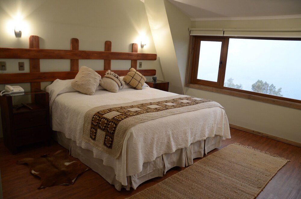 Bedroom with a wooden headboard and soft lighting at CasaEstablo