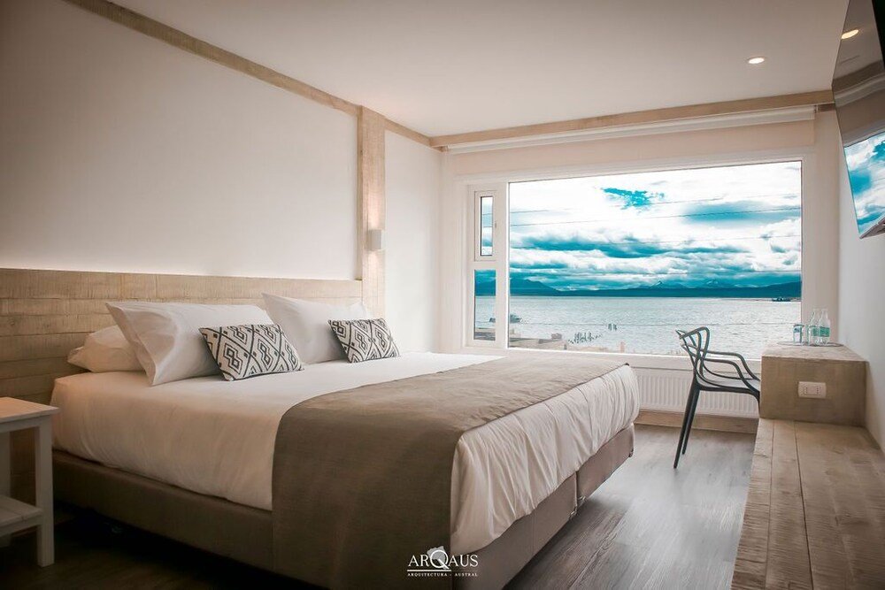 Bedroom with a large bed, sea view and a chair by the window