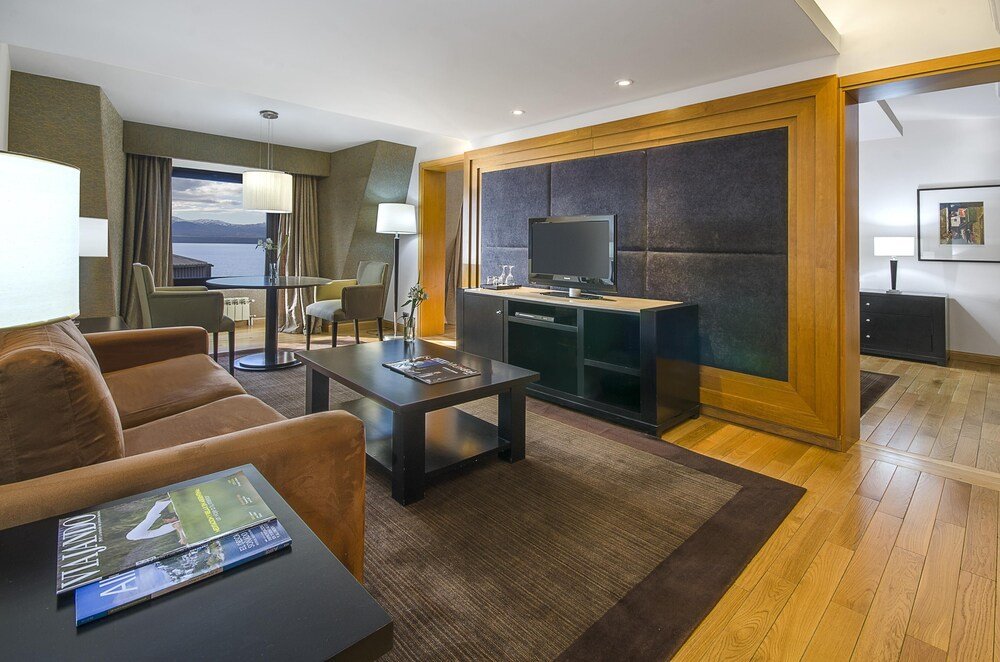 Habitación moderna con un sillón en Hotel Edelweiss