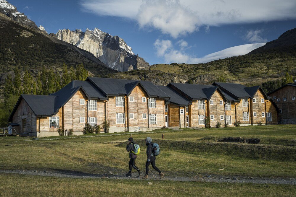 Row of wooden cabins with a mountain backdrop