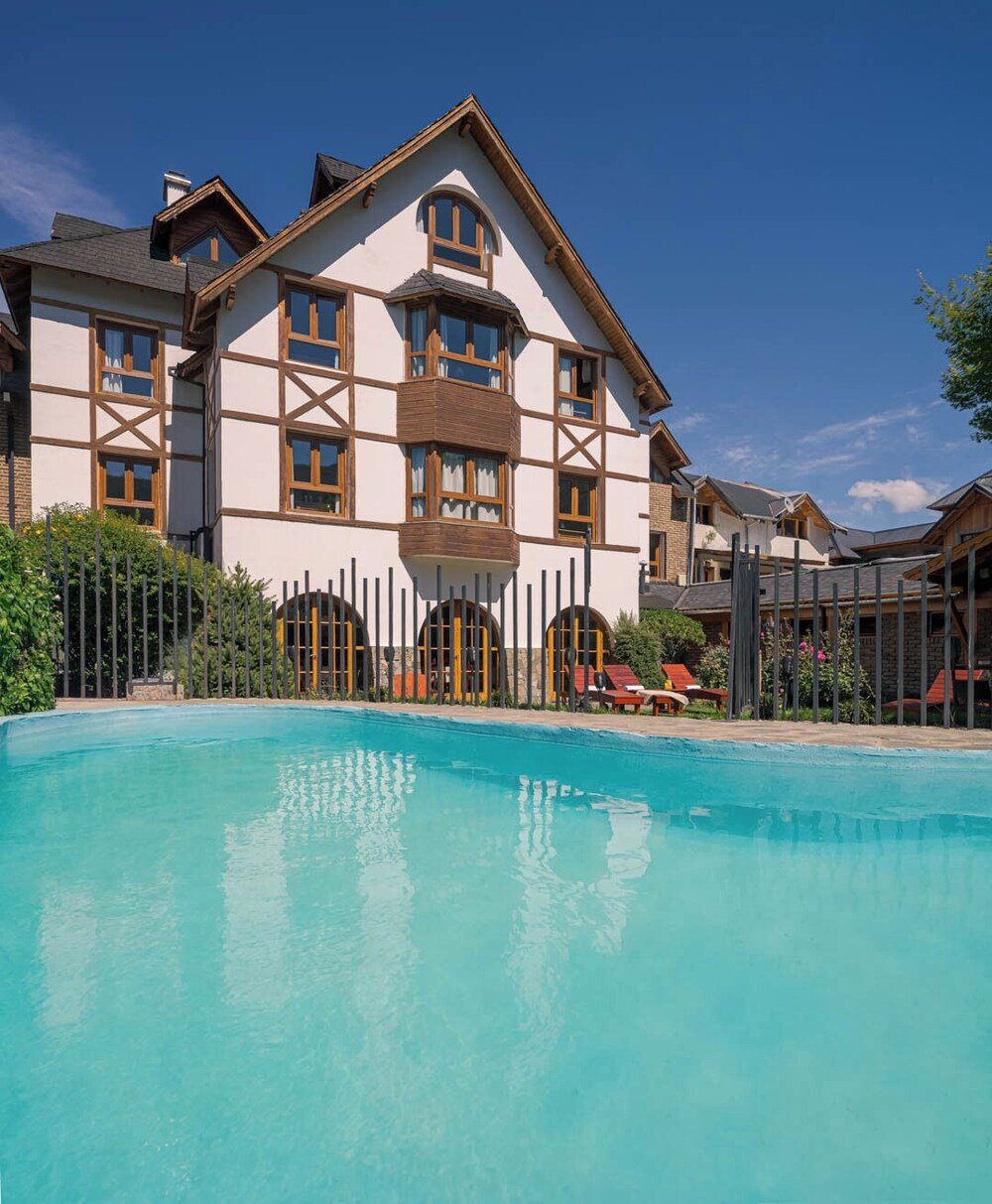 Large building with a swimming pool seen from the garden