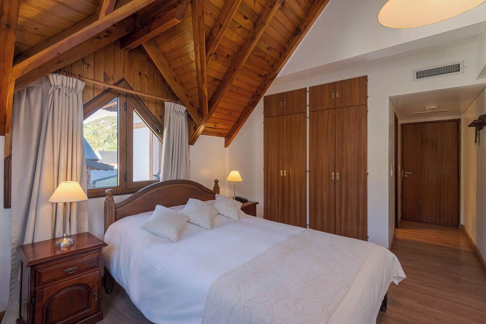 Bedroom with a wooden ceiling and soft lighting at the hotel