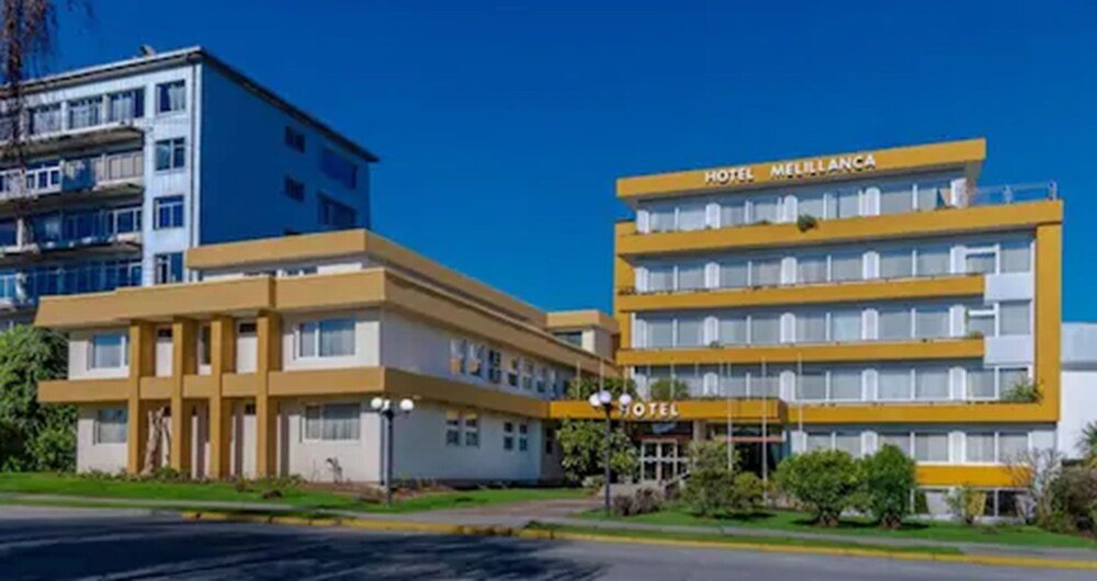 Multi-floor hotel building with yellow facade and hotel sign