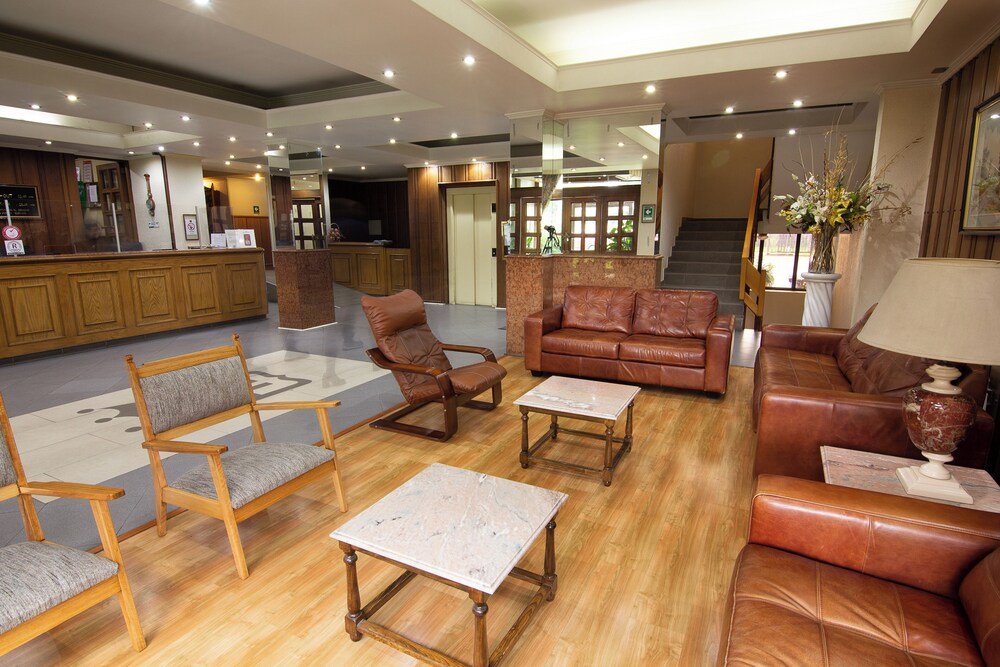 Lobby with wooden furniture, reception desk and staircase