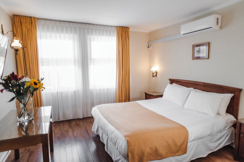 Hotel room with bed, bedside table, lamp and air conditioner