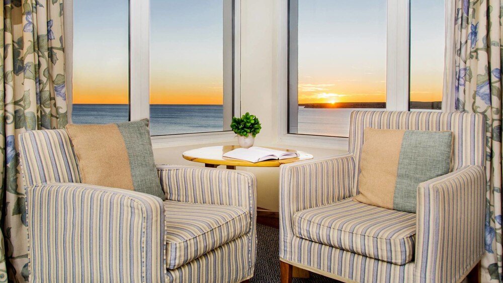 Seating area with two striped armchairs in a guest room