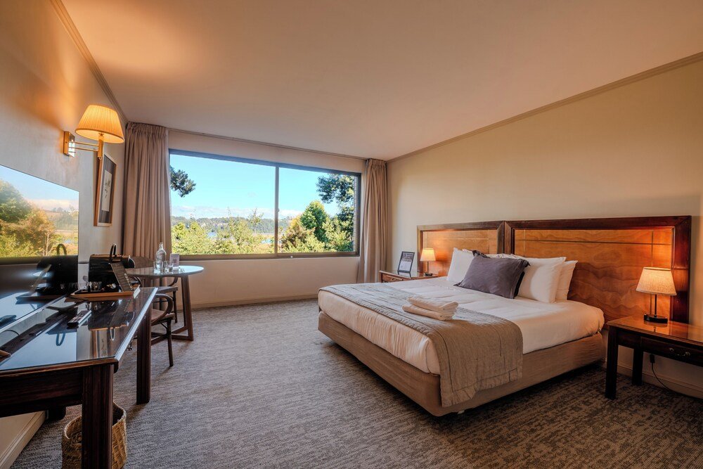 Hotel room with bed, desk, chair and lamp