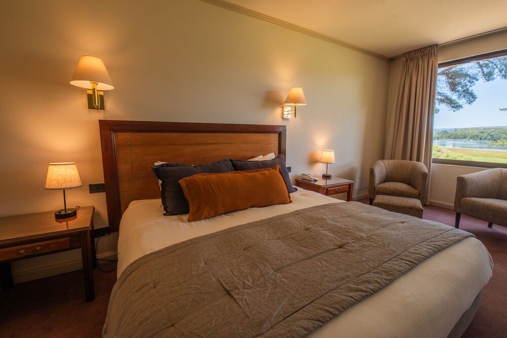Hotel room with large bed and lake view through the window