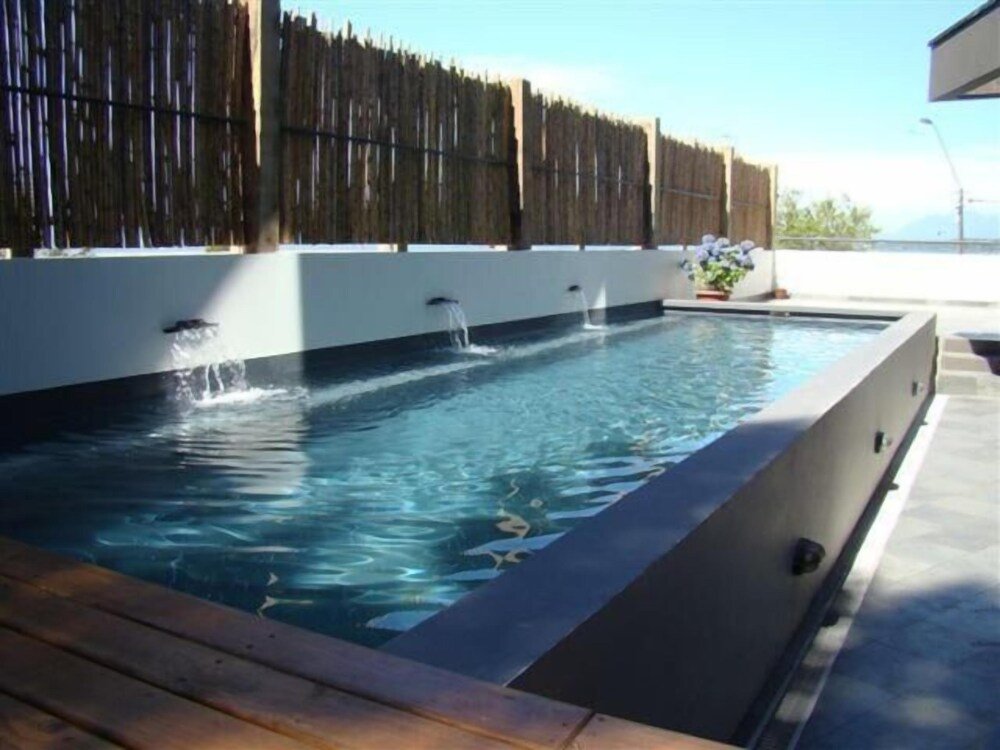 Rectangular swimming pool with wooden deck and bamboo fence