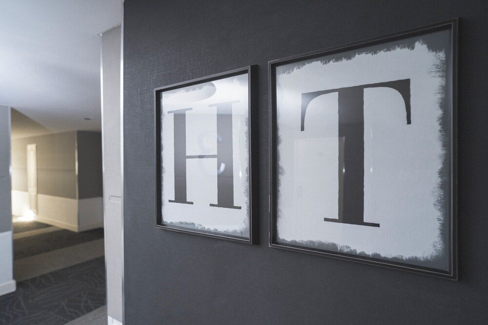Two framed letters H and T on a wall