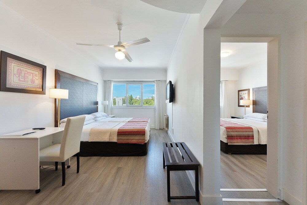 Hotel room with two beds, a desk and a bench