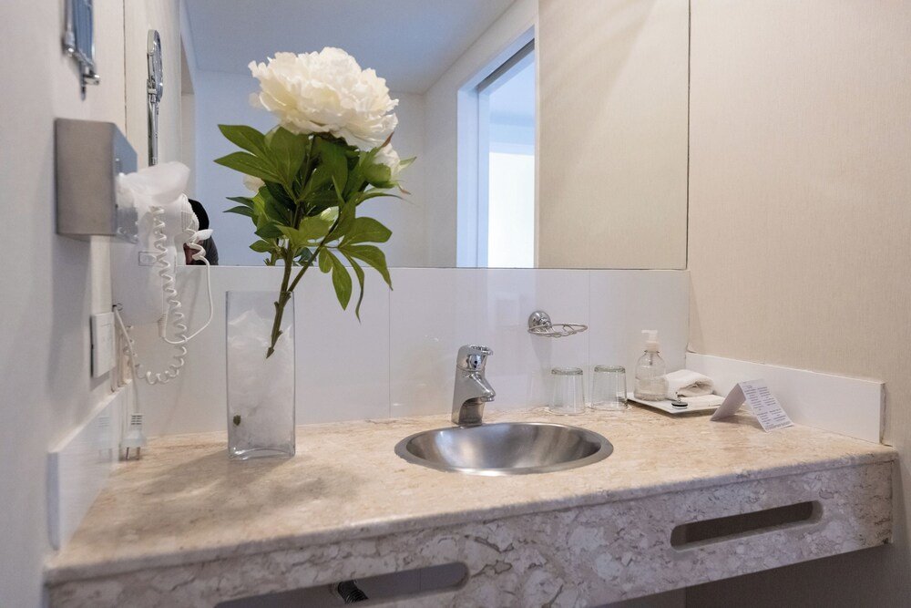 Bathroom with a marble sink, flower vase and mirror