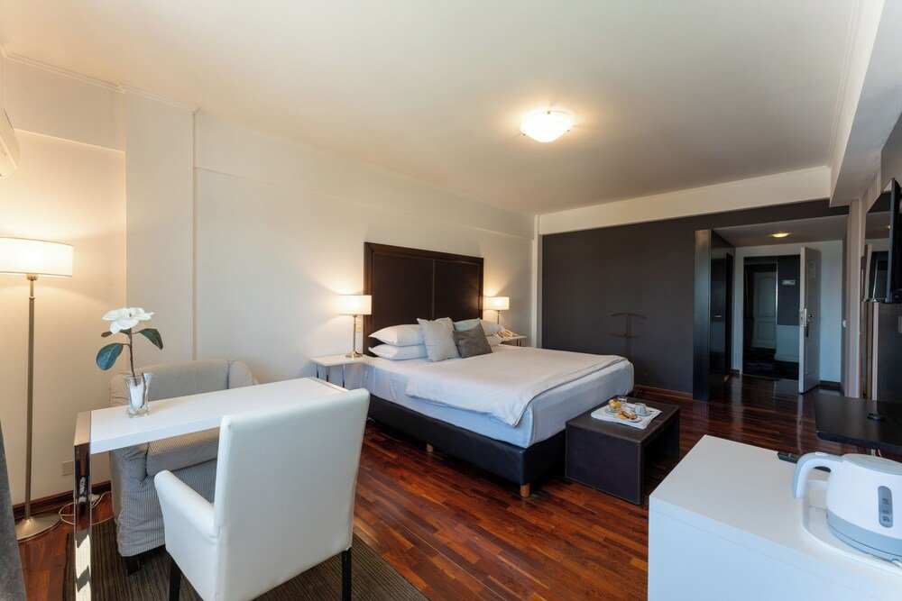 Modern hotel room with a neatly made bed and bedside lamps