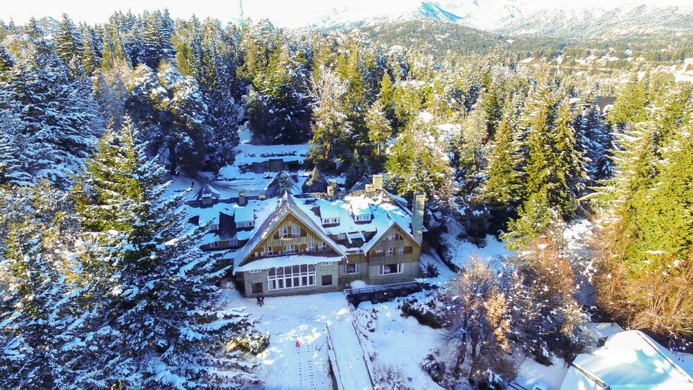 Large wooden house surrounded by trees at Hotel Tunquelén