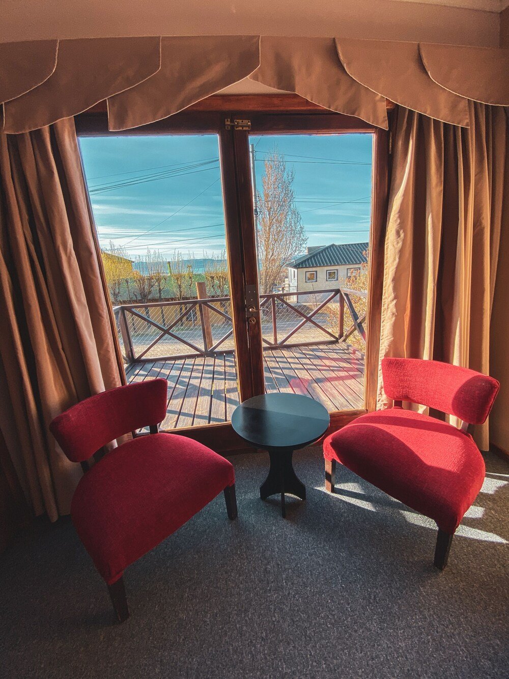 Room with two red chairs and a small table