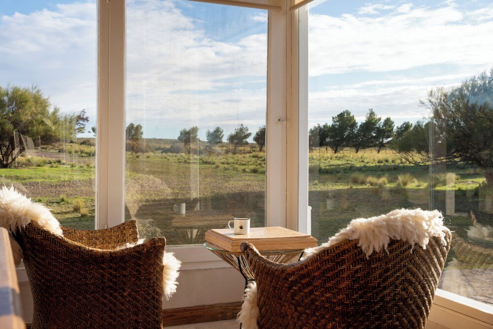 Room with two wicker chairs facing a window