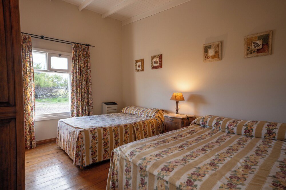 Dormitorio con dos camas y una ventana en el lodge