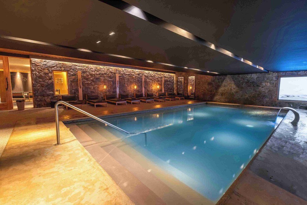 Swimming pool with a stone wall backdrop