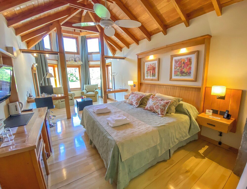 Dormitorio amplio con cama grande y vigas de madera en el techo