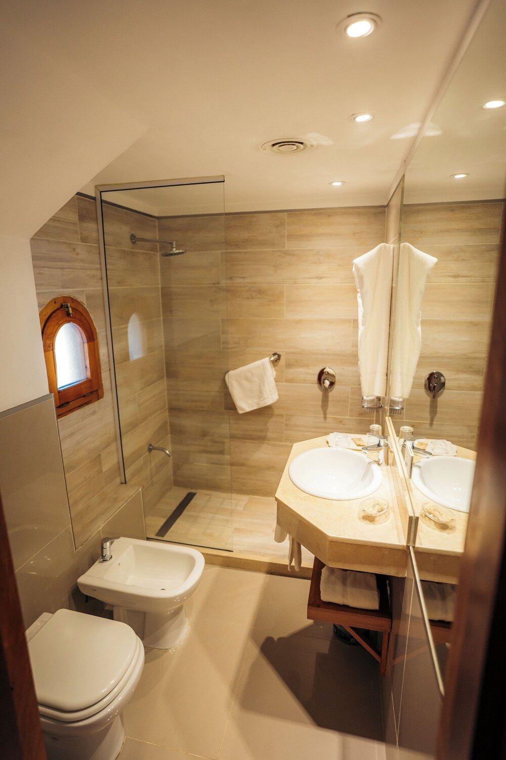 Baño moderno con ducha de vidrio y dos lavatorios