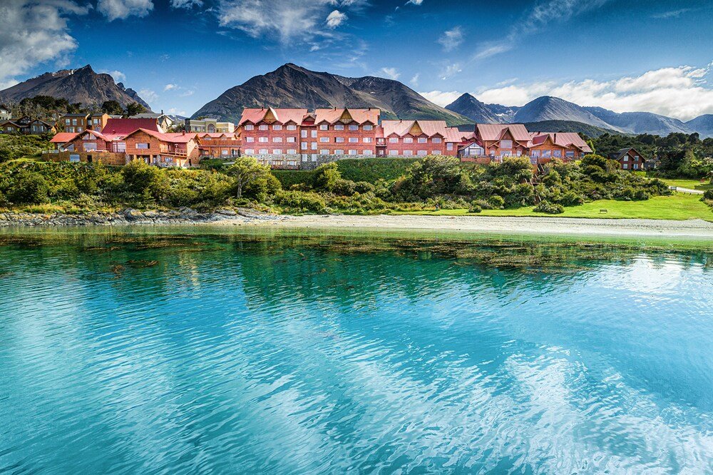 Large hotel with several red-roofed buildings by the bay