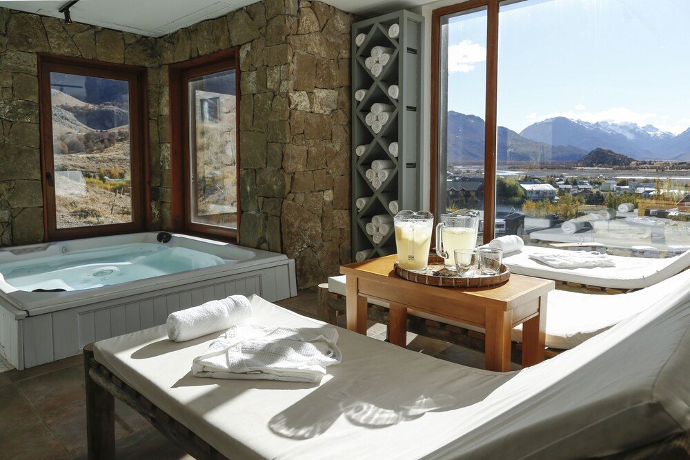 Sala de spa con jacuzzi y reposeras