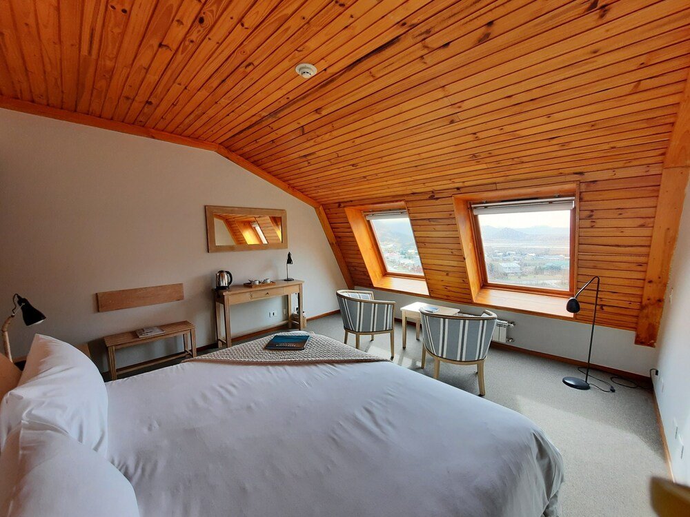 Dormitorio con techo de madera inclinado