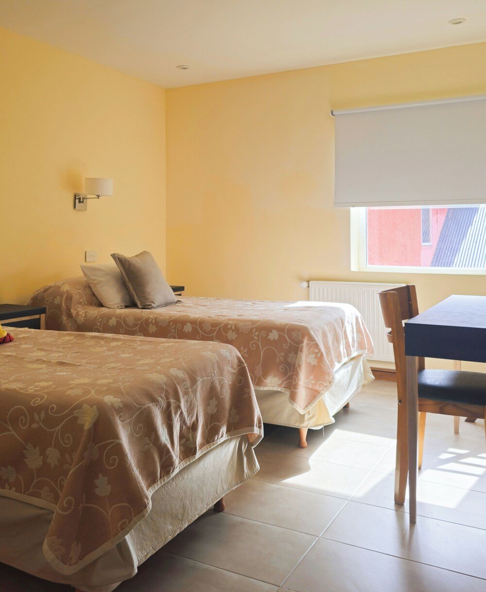 Room with two beds, a table and a chair
