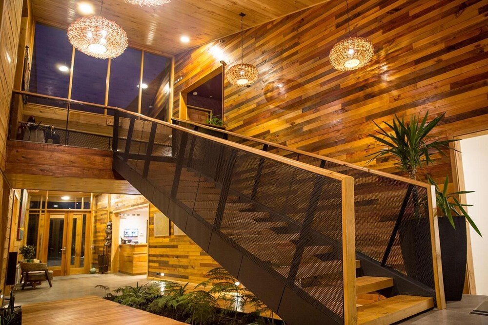 Multi-level wooden interior with staircase, large windows and hanging lights