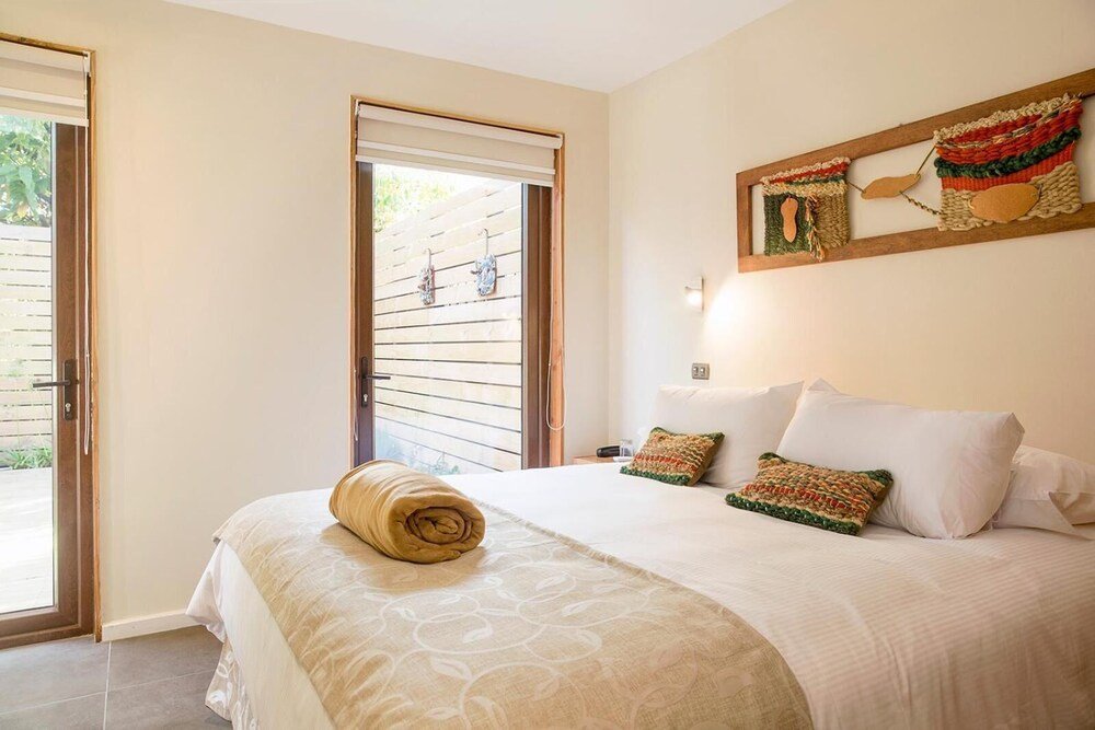 Simple bedroom with a bed, window and wall-mounted artwork