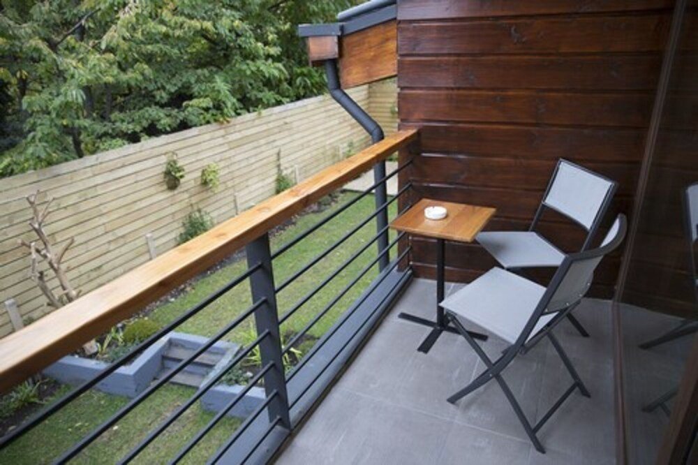 Balcony with wooden railing, small table and two chairs