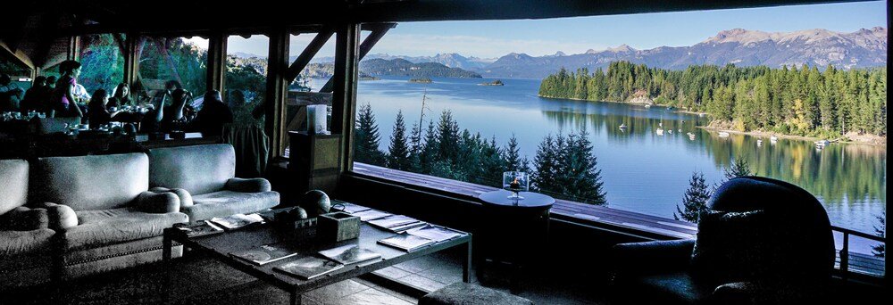 Habitación acogedora con un gran ventanal sobre el lago y las montañas