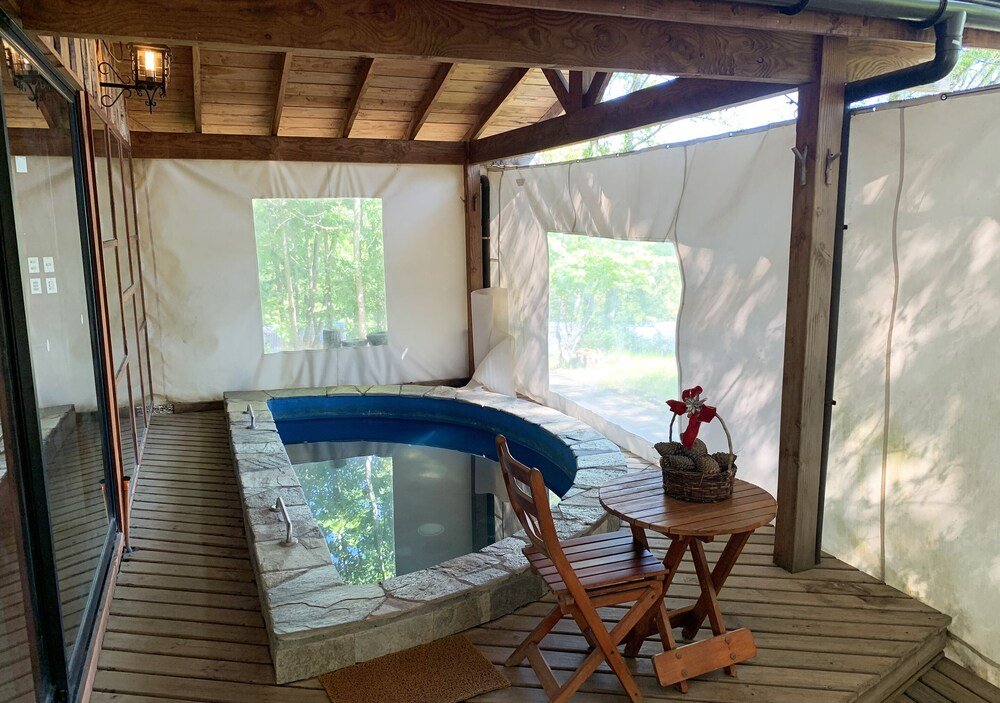 Wooden deck with a hot tub, a table with a basket and a chair