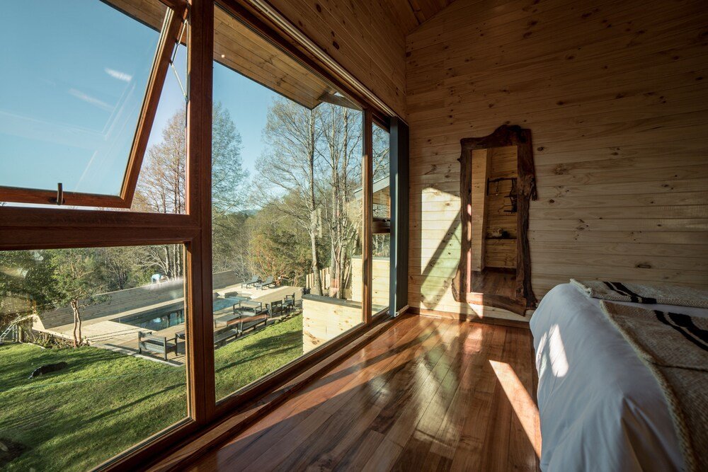 Room with large windows and wooden details at Ni-Newen lodge