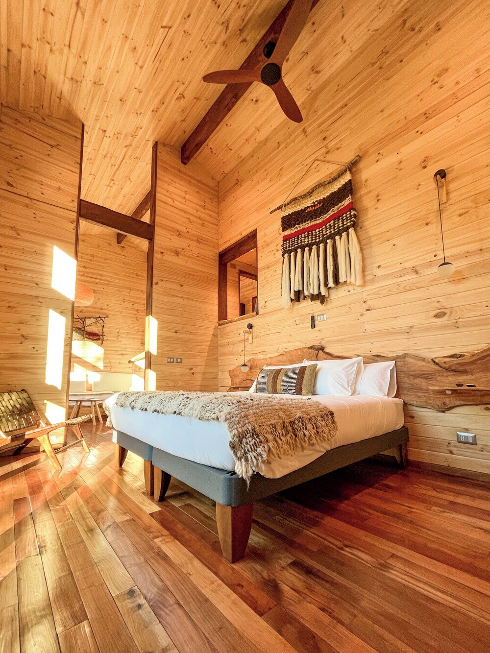 Wooden cabin interior with a bed at Ni-Newen lodge