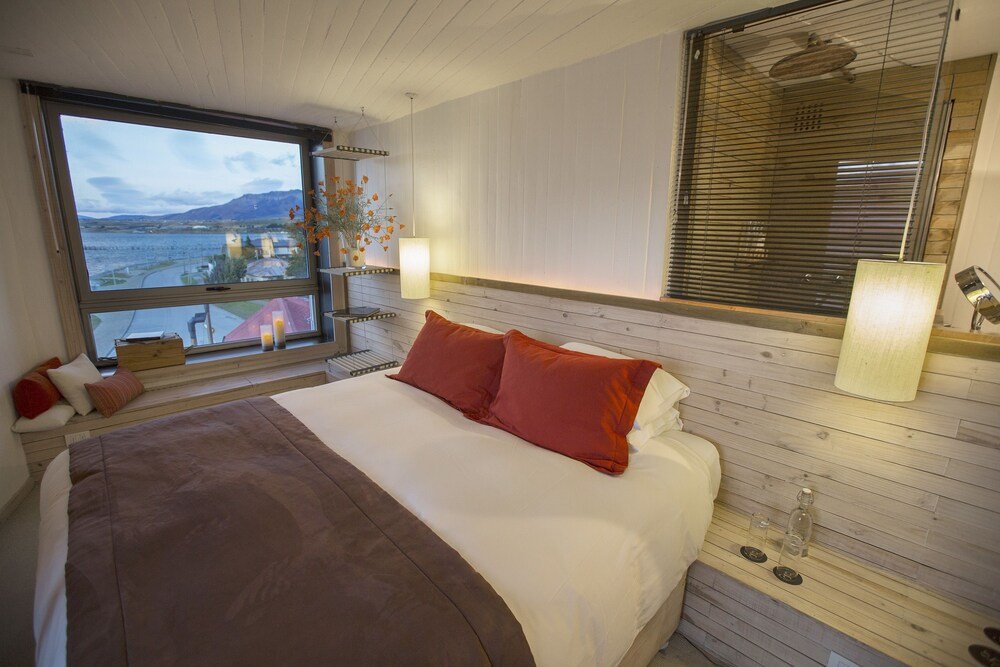 Dormitorio con cama grande y detalles de madera en Noi Indigo Patagonia