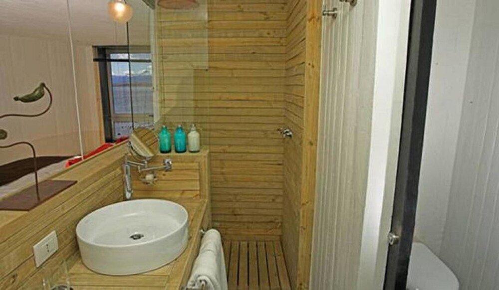Baño de madera con aire de cabaña en Noi Indigo Patagonia