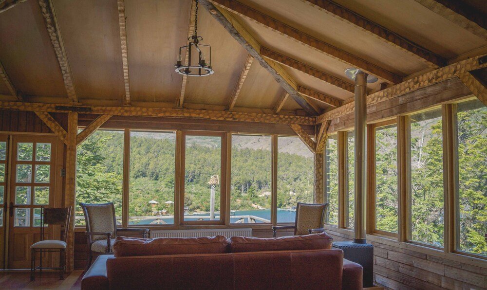 Interior de cabaña con gran ventanal y vista panorámica