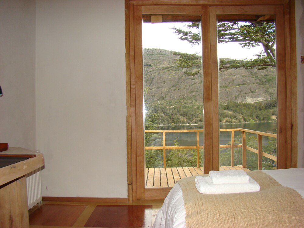 Dormitorio con cama de madera y vista a la montaña