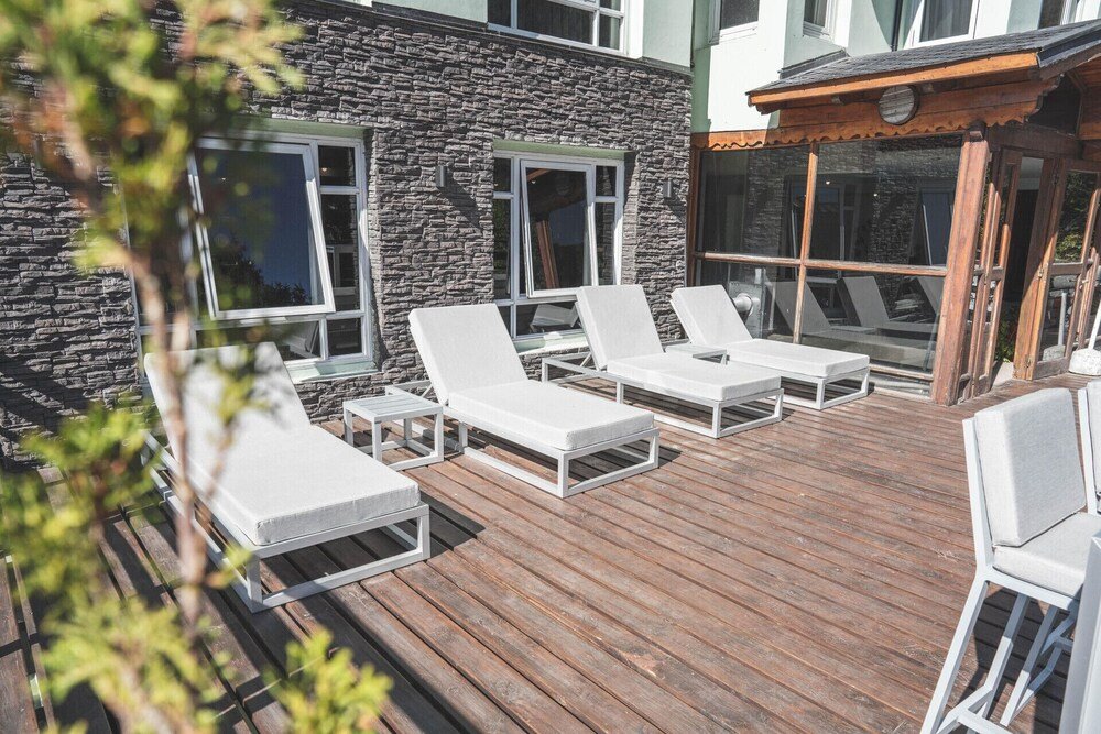 Outdoor deck with white lounge chairs at the hotel